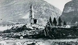 The bell tower of a church, standing above flood debris.