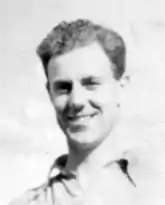 A black and white photograph of a young man showing his head and shoulders