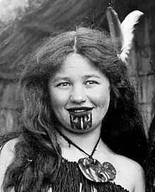 young Maori girl with chin tattoo in traditional dress.