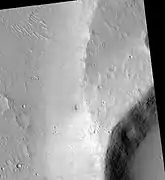 Maja Valles streamlined island in the Lunae Palus quadrangle of Mars, as seen by HiRISE.  Island formed behind the impact crater at the lower right.