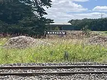 Sign reads Mannerim across single railway track