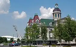 Marché Maisonneuve, a major farmer's market, with the statue La Fermière by Alfred Laliberté in the foreground and the Olympic Stadium in the background.