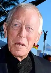 A profile image of Max von Sydow. An elderly Caucasian man with short white hair. He is facing forwards while looking off to the left, with a slight, open-mouthed smile.