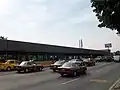 Picture of the station in the middle of Río Consolado Avenue. Several automobiles surround the station.