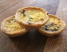 Three small individual quiches with mushrooms and pale custard filling