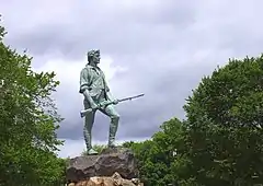 The Minuteman Statue at Lexington.  It is also referred to as a statue of Capt. John Parker, although no contemporary image of him exists.  However, a physical description of him by his grandson, Theodore Parker, does exist, and the statue generally fits that description.