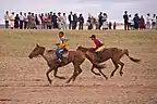 Two young riders race across the finish line.