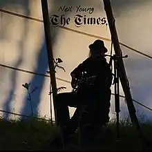 A photograph of Young playing guitar in silhouette