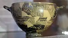 Photograph of a Greek pot in a museum case.