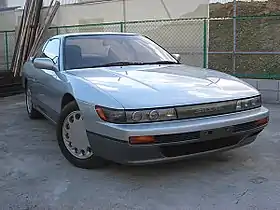 Front view of a two-door car with door mirrors