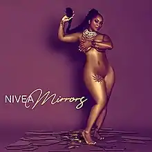 A nude woman standing on top of several mirrors while hiding her breasts and holding out her ponytail