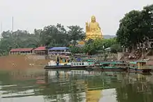 Buddha statue and tour boats at Nui Coc Lake