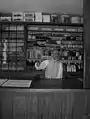 A shopkeeper displays typical early 1800s goods