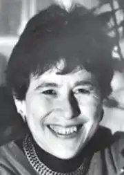 A smiling older white woman with short dark hair.