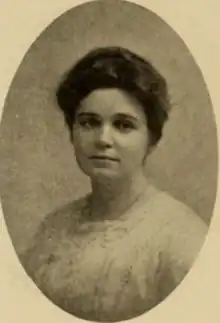 A young white woman with dark hair, wearing a white lacy shirtwaist with a high square neckline, in an oval frame