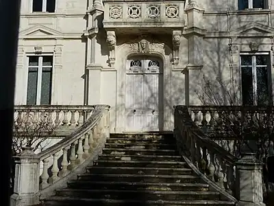 A twelve-step pyramidal staircase leads up to the front door of the white-fronted townhouse.