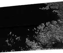 Radar image of a portion of Kraken Mare with a rugged coastline and numerous islands.