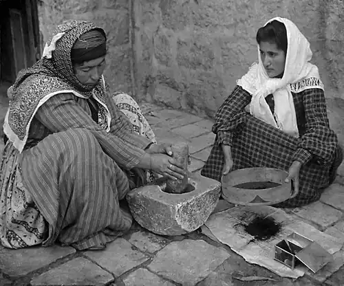 Image 91905 Stereoscope. Original caption reads: The native mode of grinding coffee, Palestine.Credit:American Colony Jerusalem (edited by Durova)