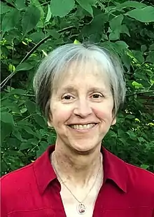 Head of Thiel in her sixties smiling in an outdoor setting.