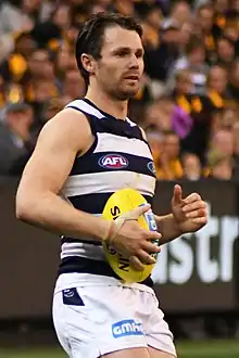 Male athlete holds a football during a game