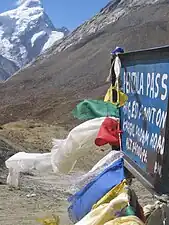 Buddhist prayer flags flutter at the highest point of the road pass