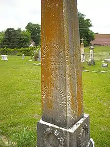 A stone obelisk marking Perry Cohea's grave