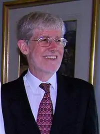 Man with white hair and beard wearing a suit