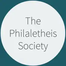 An off-white circle over a green background. In the circle in a dark, thin sans serifs font is written "The Philaletheis Society".