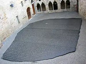 A columned-courtyard, its pavement made of a large reproduction of the Rosette stone slab.