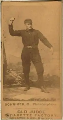 A sepia-toned blurry image of a man wearing an old-style dark-colored baseball uniform