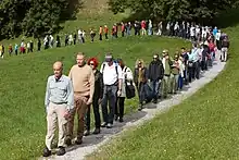 Artist Hamish Fulton leading a single-file line of walkers