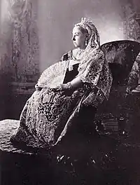 Seated Victoria in embroidered and lace dress