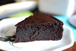 A slice of flourless quinoa chocolate cake on a white plate