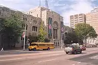 A large Italianate-Neo-Romanesque building on a tree-lined boulevard