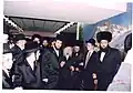 Grand Rabbi Avrohom Yissachor Englard of Radzin, on his left (our right) is seen Grand Rabbi Shlomo Yosef Englard of Radzin, with a group of Radziner Chasidim