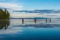 Four stumps poking out of the water in a lake with a sunset in the background