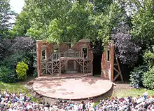 open air stage, with trees seen behind the setting