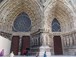 Main portal and side portal, with rose windows