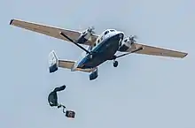 A parachuted bundle soars out of the back of a C-145 Skytruck during an air-drop mission over the Eglin Air Force Base range.