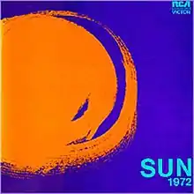 Dark blue background has an orange swirly image of the sun at left. The album's title appears at bottom right in light blue print.