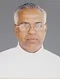 Serious, bespectacled priest in white