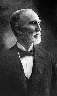 A man with a trimmed beard sits for a photograph