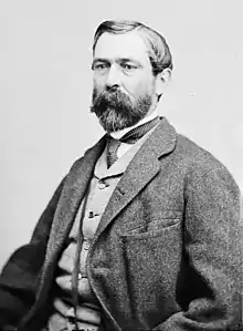 Black and white photo shows a bearded man in civilian dress.