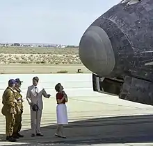 "President Ronald Reagan chats with NASA astronauts Henry Hartsfield and Thomas Mattingly on the runway as first lady Nancy Reagan scans the nose of Space Shuttle Columbia following its Independence Day landing at Edwards Air Force Base on July 4, 1982."