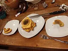 The cake (center) served onto plates (right and left) showing characteristic cake layers resembling growth rings of trees