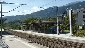 Double-tracked railway line with canopy-covered concrete platforms