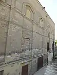 Exterior of the mosque, with the former shop alcoves visible along the base (now half-buried and below street level)