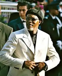 Jackson buttoning his white suit at the Cannes Film Festival in 2005