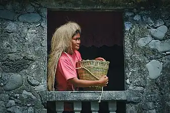 An Ivatan woman wearing a vakul inside a stone house