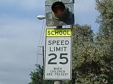 A school zone sign in the United States. When the light flashes, the set speed limit (in this case, 25 mph (40 km/h)) is active.